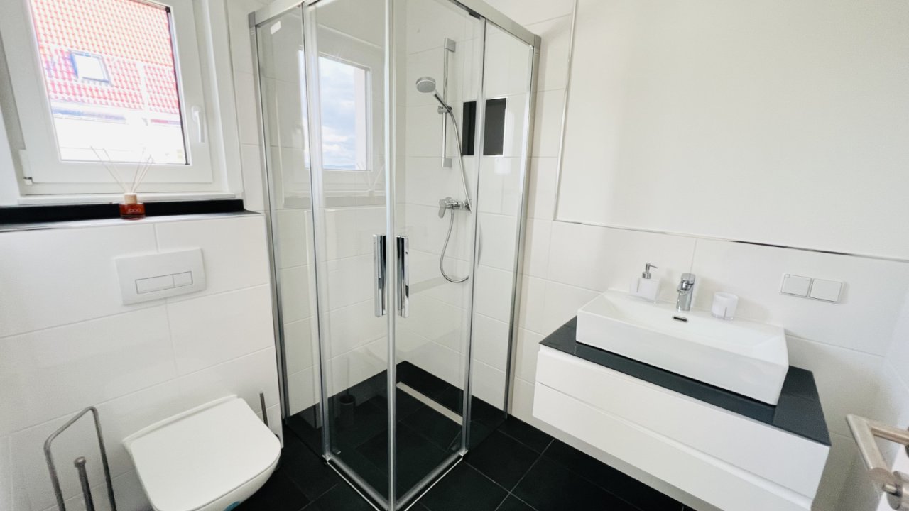 Gästebad mit bodengleicher Dusche und eleganten Einbaumöbeln Gästebad mit bodengleicher Dusche und eleganten Einbaumöbeln